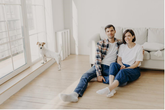 Young couple and dog sitting in a clean apartment.