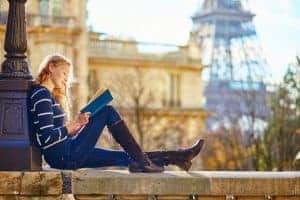 Young woman reading near the Eiffel Tower.