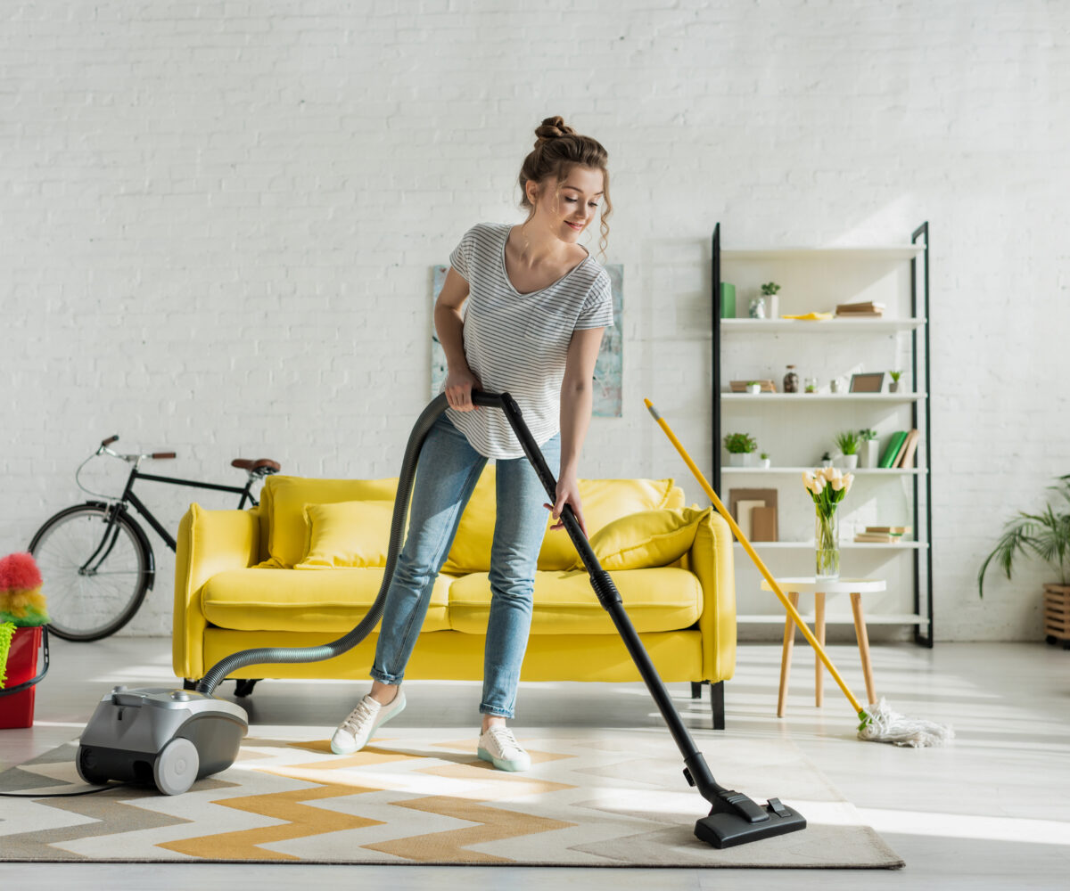 girl cleaning carpet with vaccum cleaner