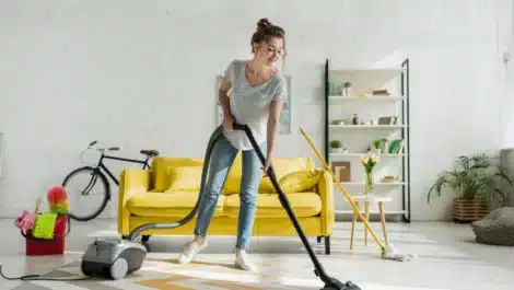 girl cleaning carpet with vaccum cleaner