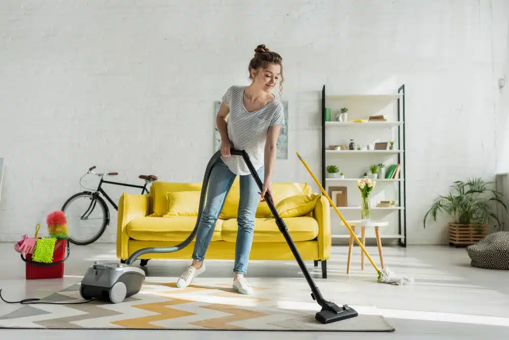 girl cleaning carpet with vaccum cleaner