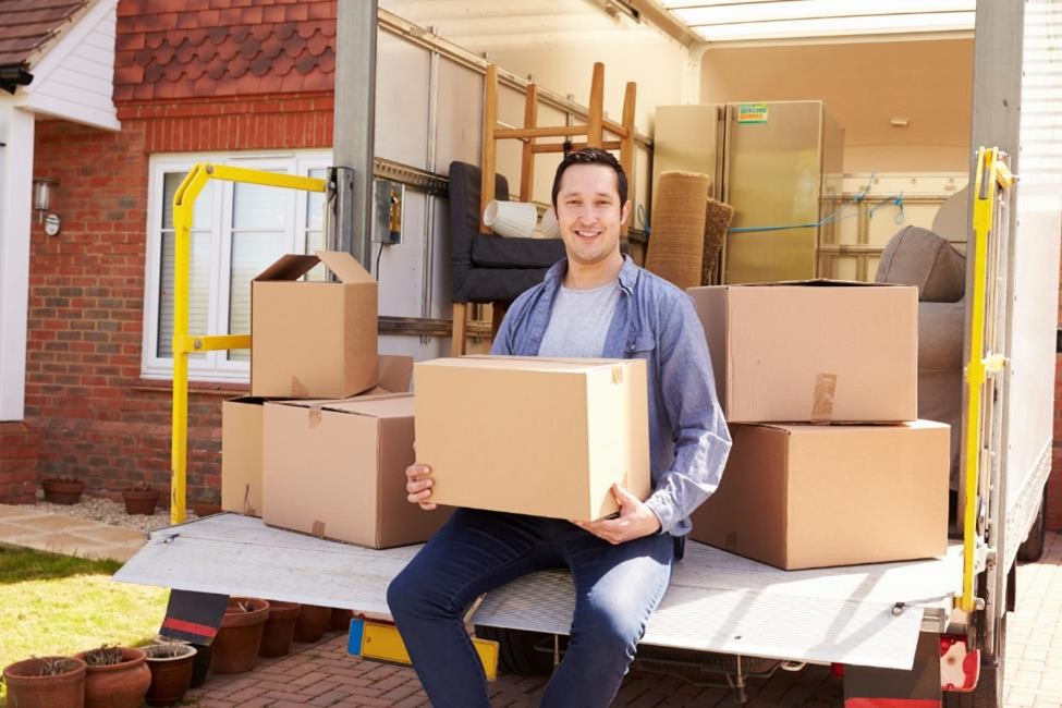 A man sitting with boxes on a moving truck