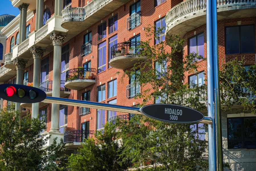 A luxury brick apartment building with a street sign in front that reads “Hidalgo 5000.”