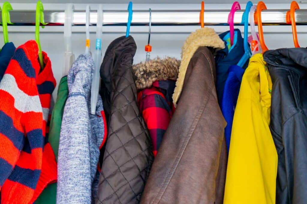 Bulky winter jackets take up space inside a coat closet.