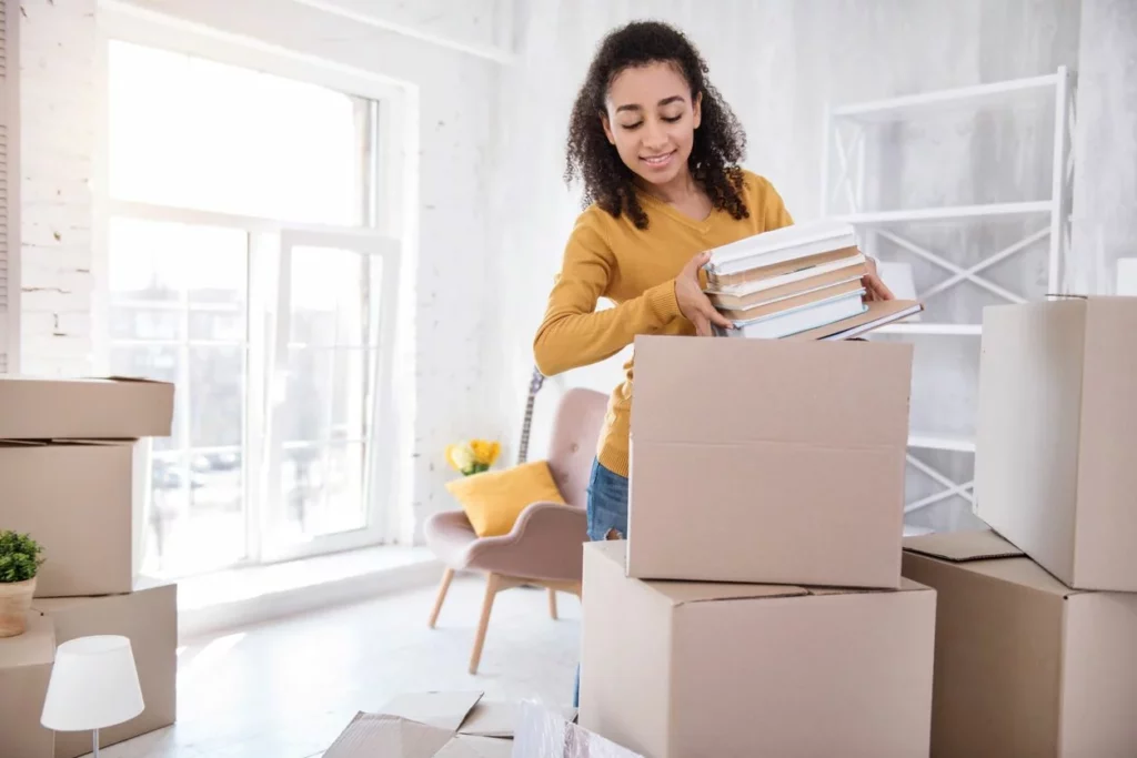 A student packing books into boxes for storage